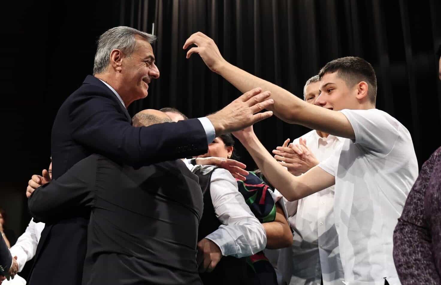 Teşekkür ve kutlama anı, gençler ve önemli kişiler sahnede birlikte.