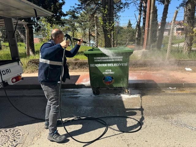 Çöp kutusu dezenfekte ve yıkama işlemi yapılıyor, hijyen ve temizlik ön planda.