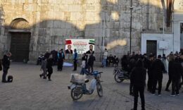 Basın Merkezi girişinde toplanmış gazeteciler ve ziyaretçiler, güvenlik önlemleri alınmış.