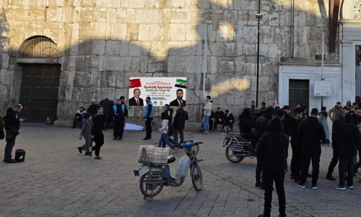 Basın Merkezi girişinde toplanmış gazeteciler ve ziyaretçiler, güvenlik önlemleri alınmış.